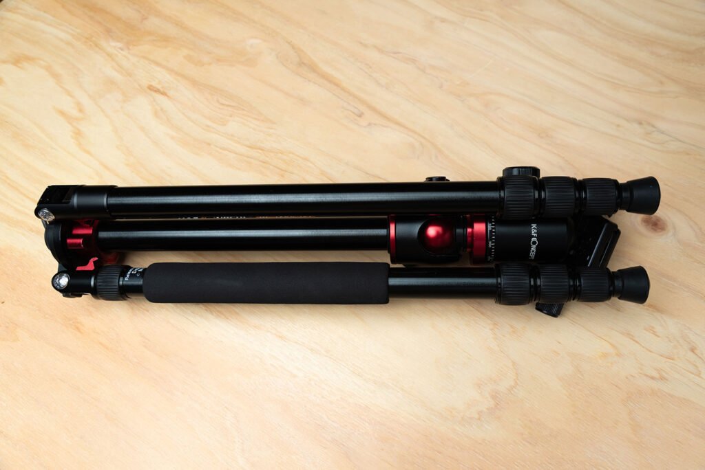 K&F Concept travel tripod on wooden surface, compact and lightweight